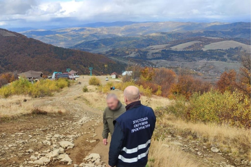 Ґрунтова дорога з камінням на горі Гимба і працівник Хустської окружної прокуратури під час огляду
